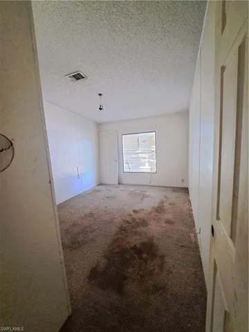 Spare room with carpet floors and a textured ceiling