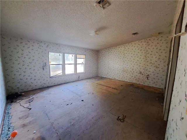 Unfurnished room with a textured ceiling