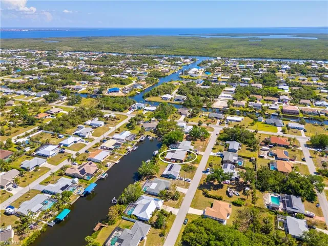 Aerial overview of property's location featuring a nearby body of water and nearby suburban area