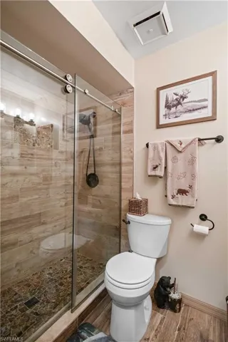 Full bathroom with a shower stall and wood finished floors