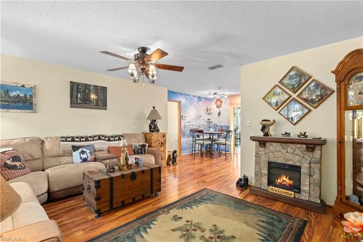 Living room wood finished floors, a textured ceiling, and ceiling fan