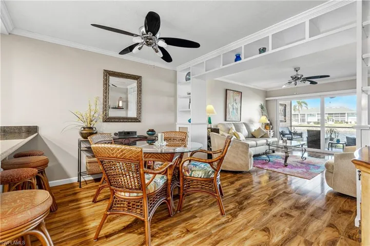 Dining area featuring wood finished floors, ceiling fan, baseboards, and ornamental molding