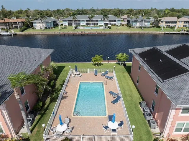 Birds eye view of property featuring a water view and pool