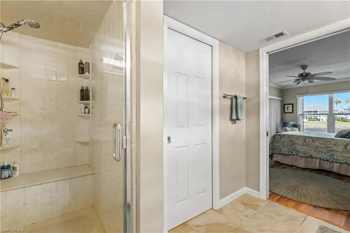 Bathroom featuring baseboards, ensuite bath, and a stall shower