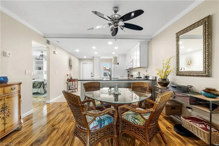 Dining space featuring light wood-style flooring, baseboards, a ceiling fan, and crown molding