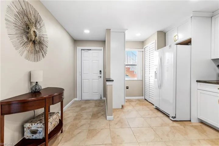 Foyer entrance featuring light tile patterned flooring, baseboards, and recessed lighting
