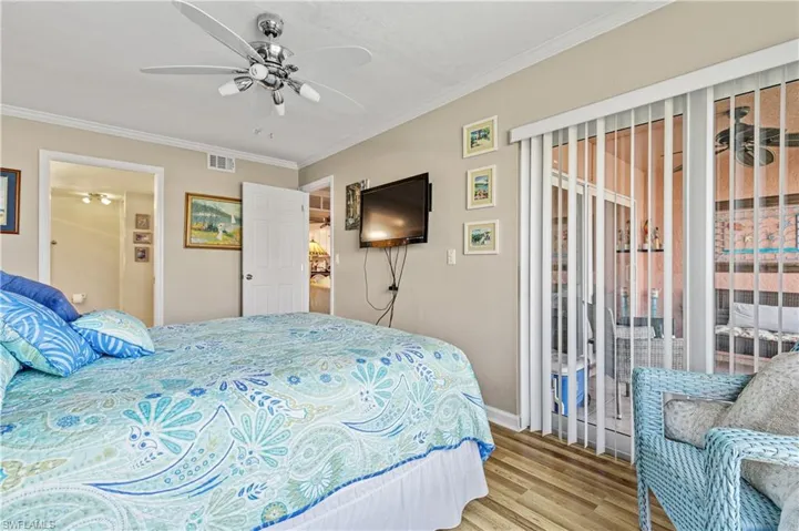 Bedroom featuring access to outside, ornamental molding, a ceiling fan, and wood finished floors
