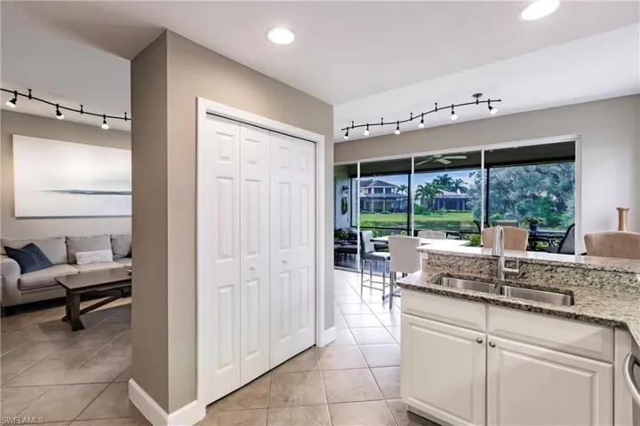Kitchen with track lighting, light stone countertops, and light tile patterned flooring