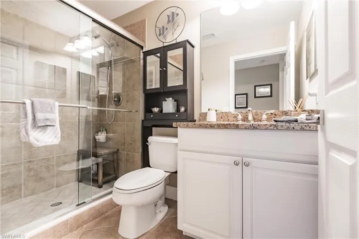 Full bathroom featuring vanity, a stall shower, and light tile patterned floors