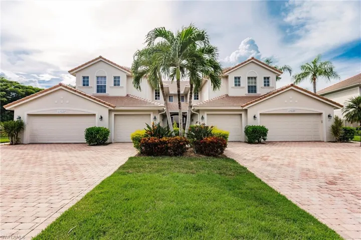 Mediterranean / spanish-style home featuring stucco siding, a front lawn, driveway, and a tile roof