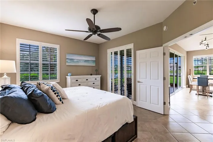 Bedroom with access to exterior, multiple windows, light tile patterned floors, and ceiling fan