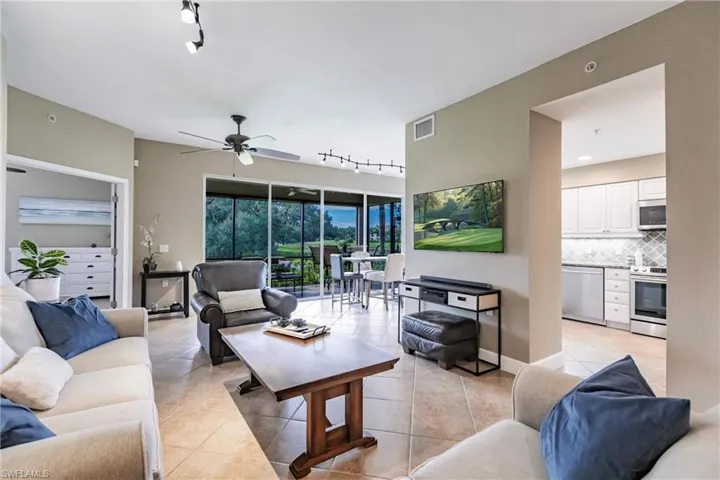 Living room with rail lighting, light tile patterned flooring, and ceiling fan