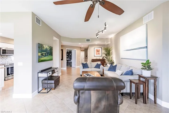 Living room with light tile patterned floors and ceiling fan