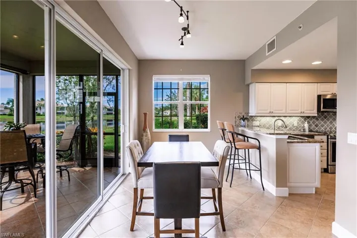 Dining room with recessed lighting, light tile patterned floors, a water view, and rail lighting