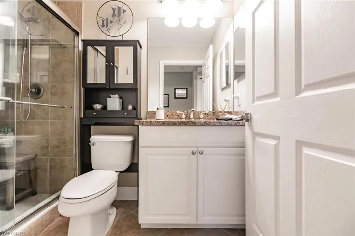 Full bathroom featuring vanity, a stall shower, and tile patterned floors