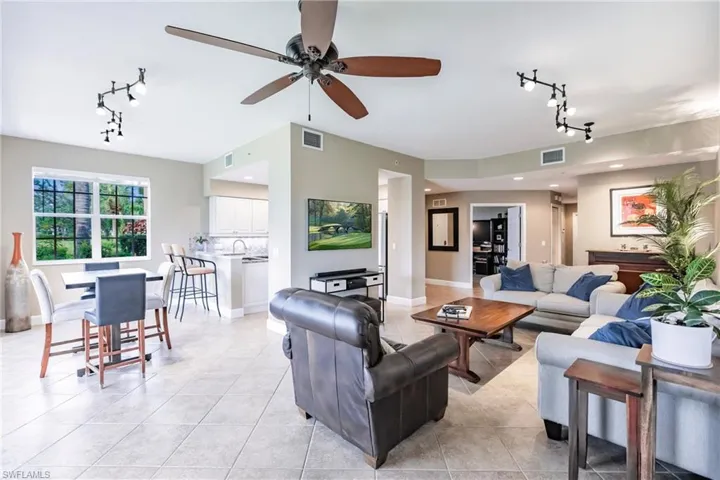 Living area with track lighting, ceiling fan, and light tile patterned floors