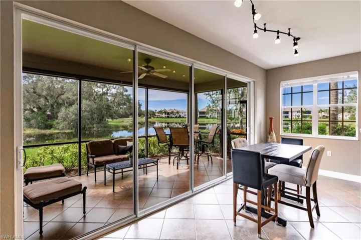 Dining area with a water view, light tile patterned floors, and a ceiling fan