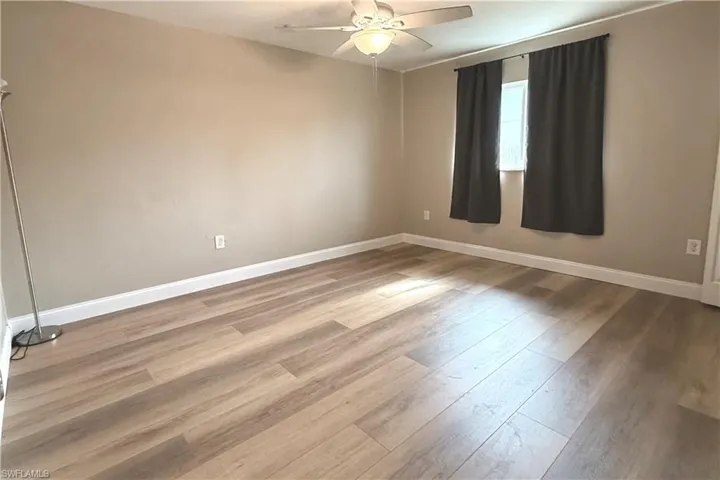 Empty room featuring a ceiling fan and wood finished floors