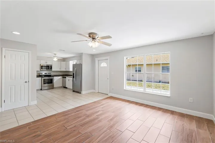 Unfurnished living room featuring wood tiled floors, a ceiling fan, and recessed lighting