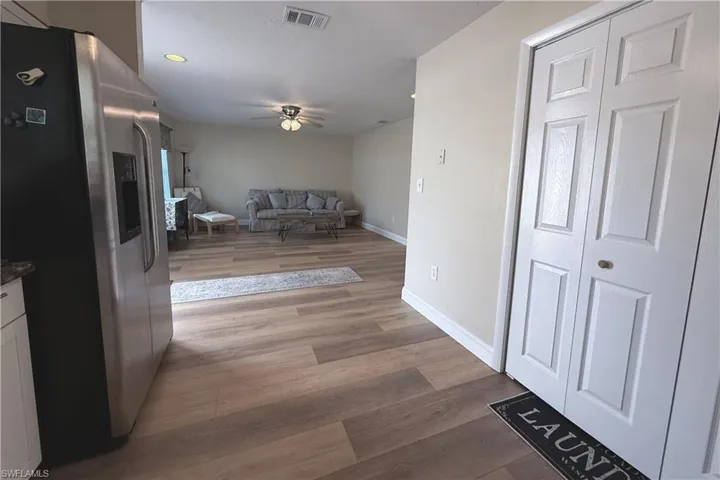 Hallway with light wood-type flooring and recessed lighting