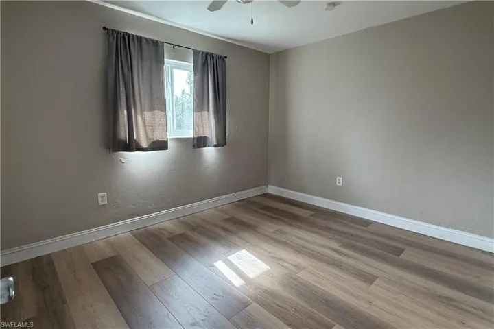 Empty room with wood finished floors and ceiling fan