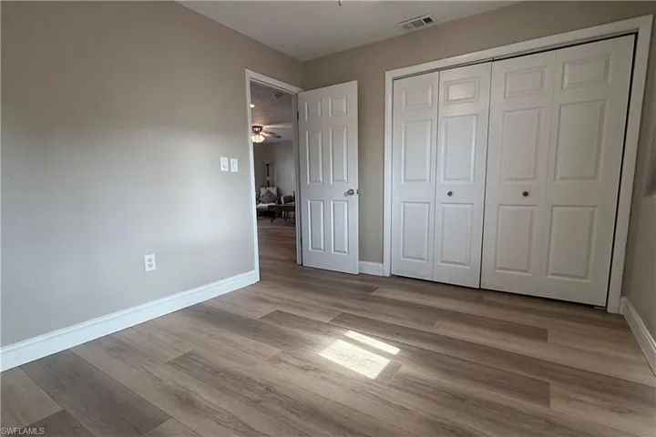 Unfurnished bedroom featuring wood finished floors and a closet