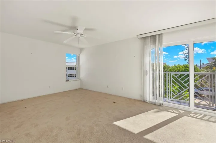 Carpeted spare room featuring ceiling fan