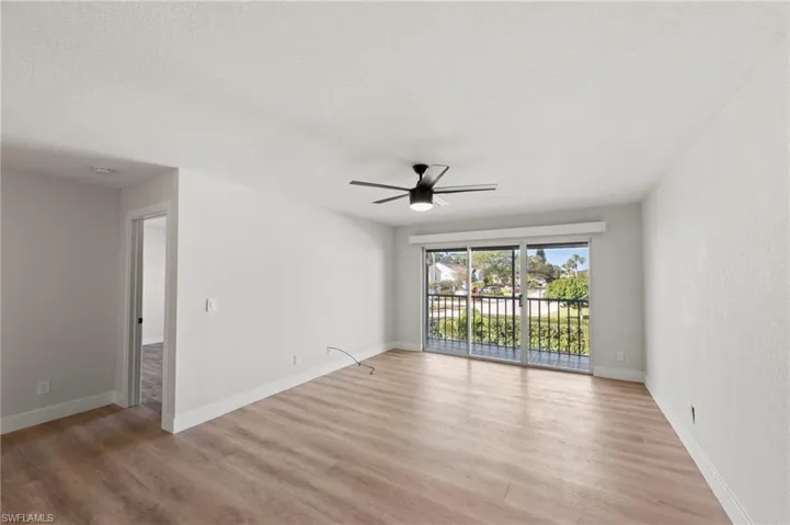 Unfurnished room featuring light wood-style flooring, a ceiling fan, and a textured ceiling