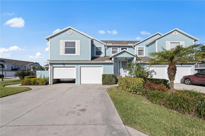 View of front facade featuring concrete driveway, an attached garage, a front lawn, and a shingled roof