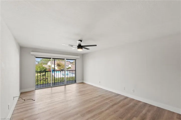 Unfurnished room with a ceiling fan, a textured ceiling, and light wood finished floors
