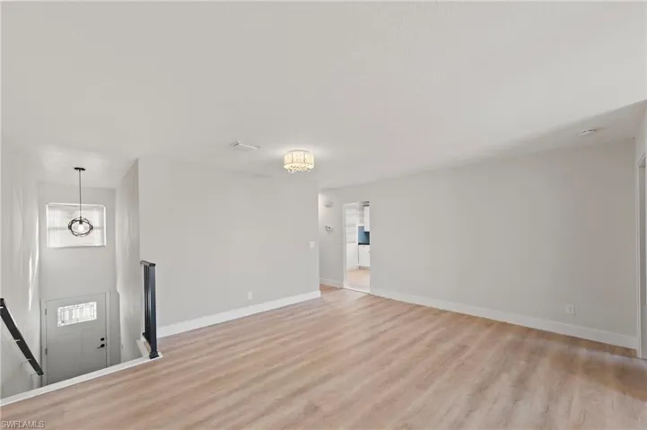 Unfurnished living room featuring baseboards and light wood-style flooring
