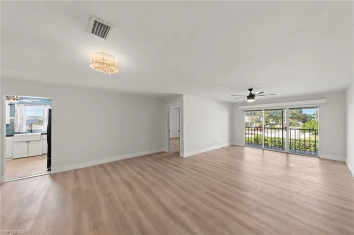 Unfurnished living room featuring ceiling fan, plenty of natural light, light wood finished floors, and a textured ceiling
