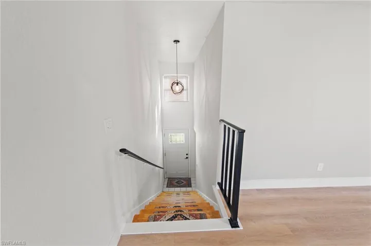 Stairway featuring wood finished floors and a high ceiling