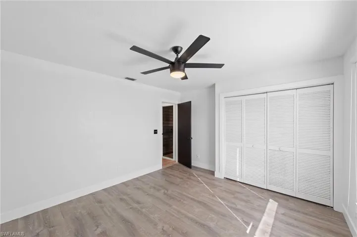 Unfurnished bedroom with a closet, light wood-style flooring, and ceiling fan