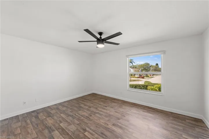 Spare room with dark wood-style flooring and a ceiling fan