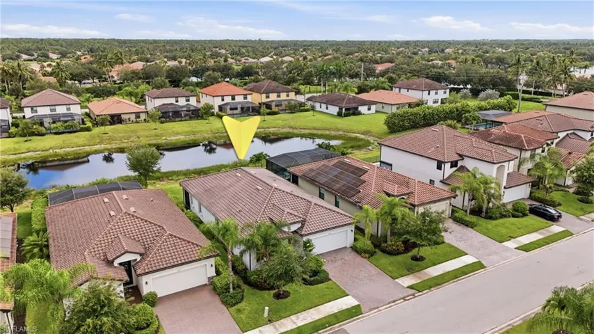 Aerial view of a residential property with a multi-tile roof, featuring a paved driveway and an attached two-car garage