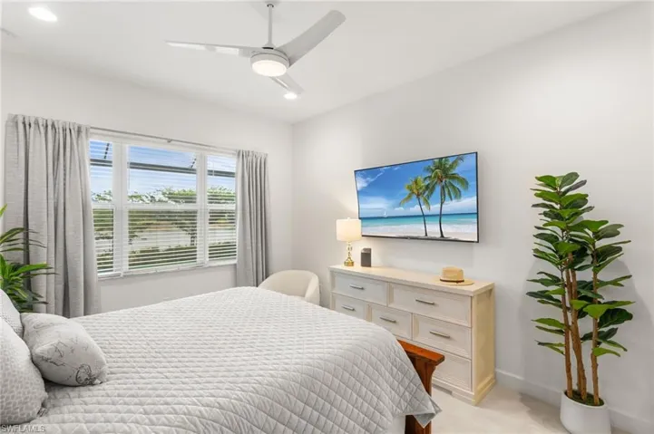 Bedroom with ceiling fan, light carpet, and recessed lighting