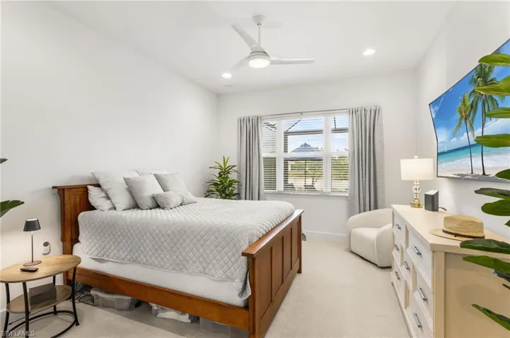 Bedroom with light carpet, a ceiling fan, and recessed lighting