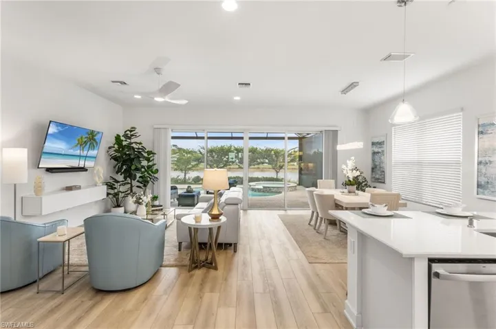 Living area featuring light wood-style floors, ceiling fan, and recessed lighting