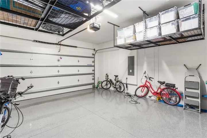 Garage featuring electric panel and a garage door opener