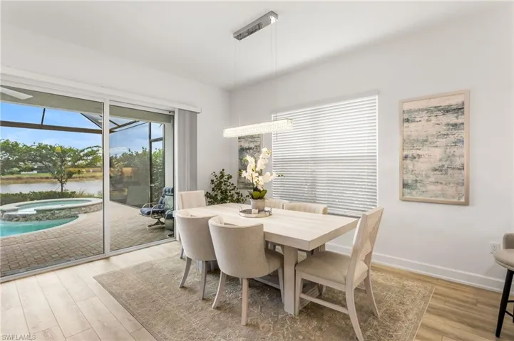 Dining area featuring light wood finished floors, a water view, and a sunroom