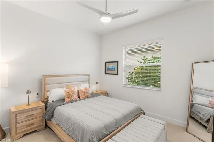 Bedroom with light carpet and a ceiling fan