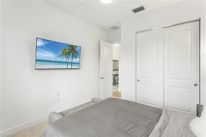 Bedroom with a ceiling fan, light colored carpet, and a closet