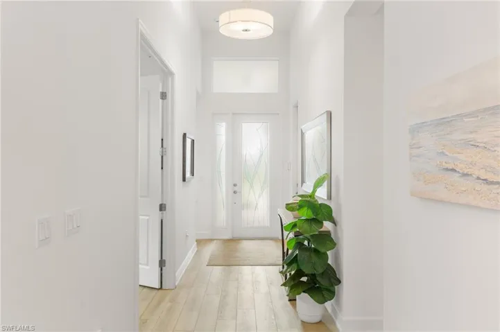 Entryway with light wood-style floors and a high ceiling