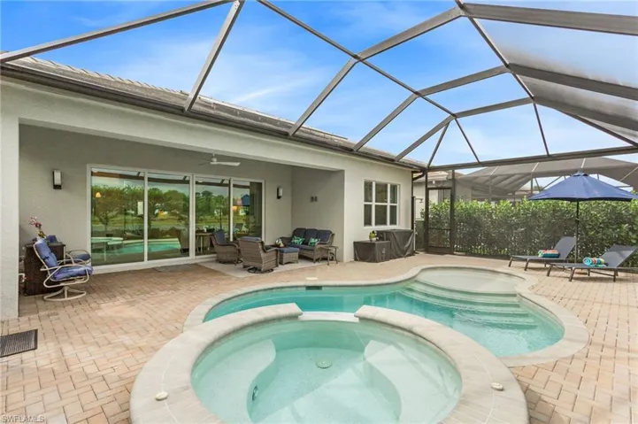 Relaxing pool / spa with a sunroom, outdoor lounge area, a lanai, and a patio area