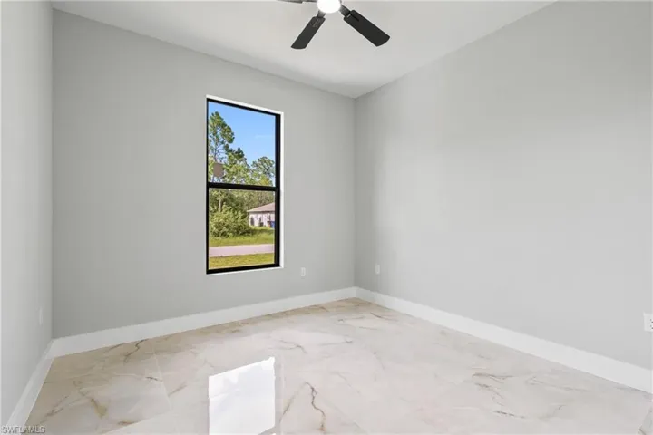 Spare room featuring marble finish flooring and ceiling fan