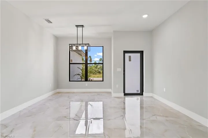Unfurnished dining area featuring light marble finish flooring, a chandelier, and recessed lighting