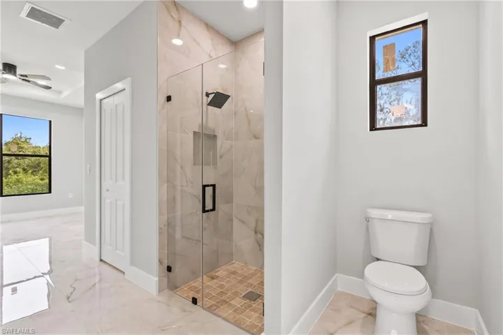 Bathroom featuring marble tiled flooring and a marble finish shower