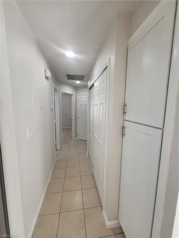 Corridor featuring baseboards and light tile patterned floors