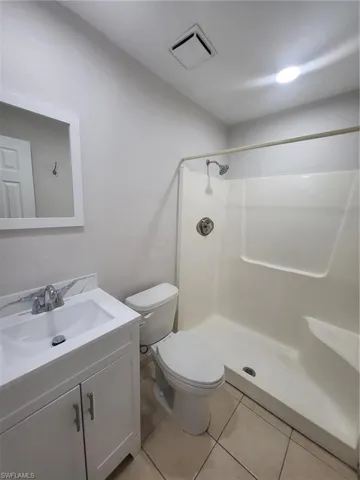 Full bath featuring vanity, a stall shower, and light tile patterned floors